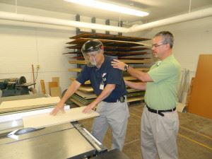 man helping to cut board